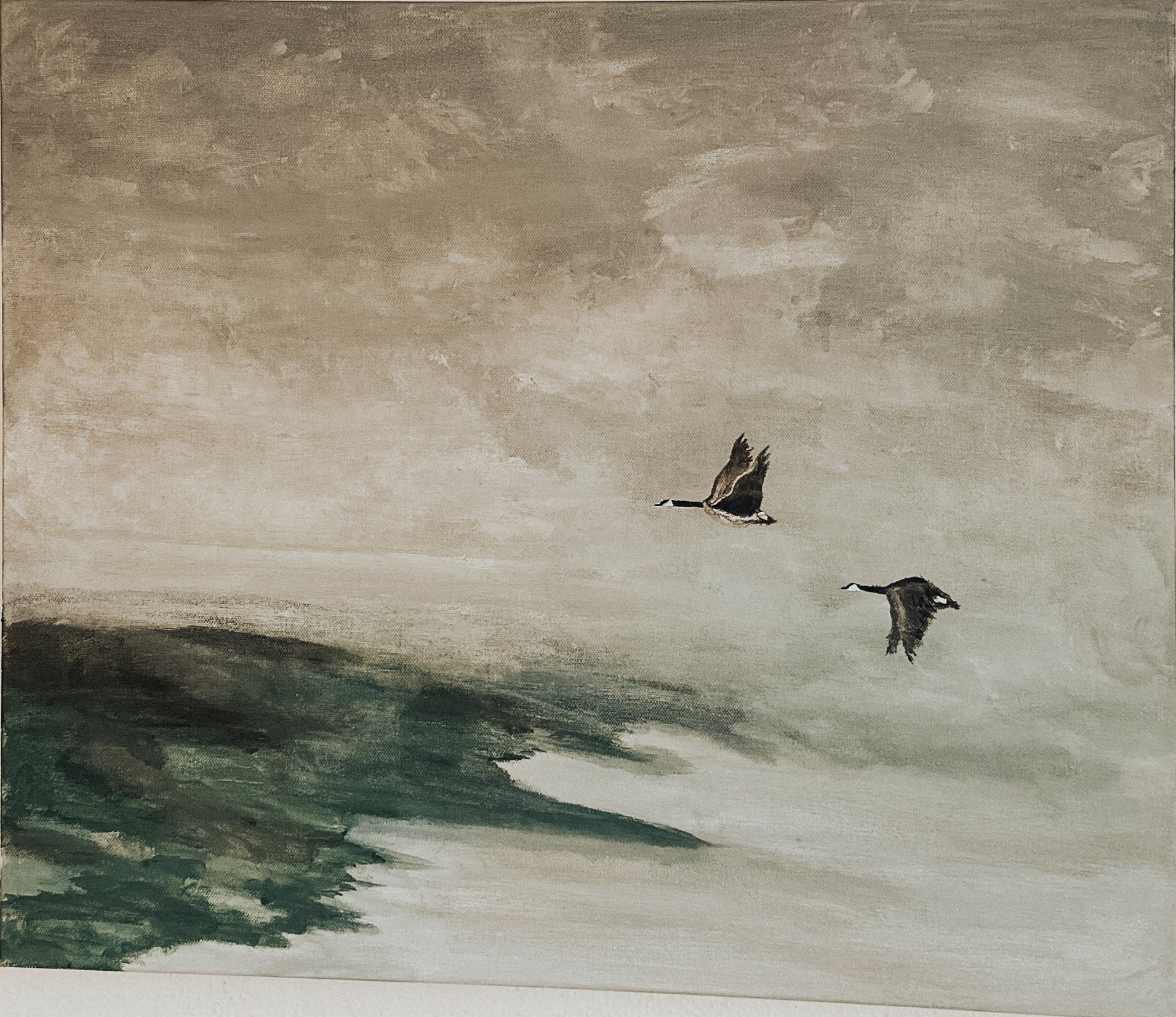 Going — two geese in flight over a wide sand-coloured sky and dark shore